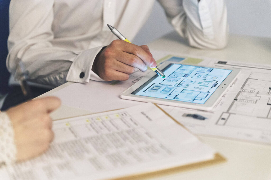 Engineer reviewing digital building plans on a tablet for the Building Identity Certificate