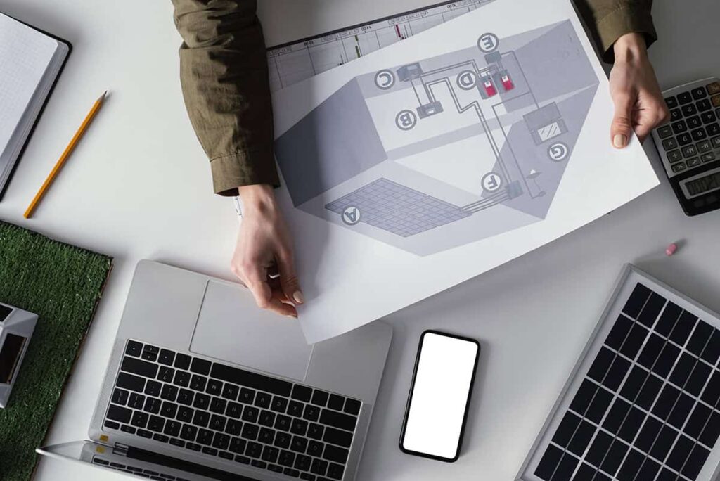 Μηχανικός αναλύει αποτελέσματα μη καταστροφικών ελέγχων σε σχέδια και υπολογιστή